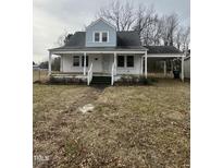 Quaint home featuring a covered porch and carport, set on a lot with mature trees at 728 East Ave, Henderson, NC 27536