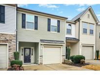 Two-story townhome features a one car garage, beautiful siding, and a well maintained landscape at 94 E Grove Point Dr, Clayton, NC 27527