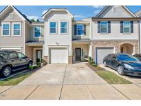 Townhome exterior featuring a one-car garage, stone accents, and a driveway at 1019 Grand Ridge Dr, Rolesville, NC 27571