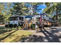 Charming single story home featuring a wooden deck, walkway and beautiful, mature landscaping at 104 Piquot Drive, Louisburg, NC 27549