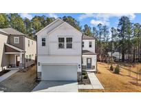 Charming two-story home with a modern white exterior, complemented by a spacious driveway and manicured lawn at 1107 Depot Dr, Durham, NC 27703
