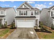 Charming two-story home with gray siding, black shutters, well-maintained landscaping, and a two car garage at 112 Velten Ridge Dr, Durham, NC 27713