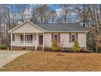 Charming single-story home with a welcoming front porch and well-maintained landscaping at 118 Gracie Ln, Clayton, NC 27520