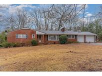 Charming brick home featuring a metal roof, established landscaping, and a two-car garage at 2005 Sutphin Dr, Sanford, NC 27330