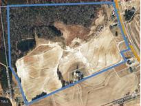 An aerial view showing the large property including trees and road access at 2113 Nc 55, Coats, NC 27521