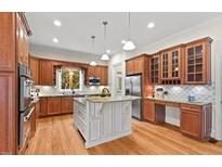 Spacious kitchen with custom cabinets, granite countertops, stainless appliances, and a large island at 216 Copper Beech Ct, Chapel Hill, NC 27517