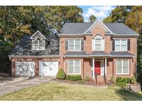 Charming two-story brick home with a well-manicured lawn and attached two car garage at 407 Crickentree Dr, Cary, NC 27518
