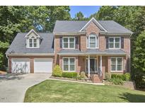 Two-story brick home with a well-manicured lawn and attached two-car garage at 407 Crickentree Dr, Cary, NC 27518