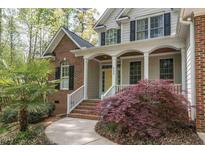 Charming two-story home with a brick facade, covered porch, and well-manicured landscaping at 4325 New Hope Springs Dr, Hillsborough, NC 27278