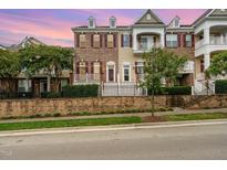 Beautiful townhome featuring brick facade, shutters, and white accents, plus manicured landscaping at 9221 Calabria Dr # 116, Raleigh, NC 27617