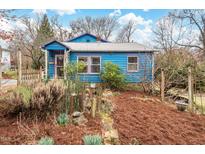 Charming blue bungalow-style home with a manicured front yard and unique artistic accents at 107 Hillview St, Carrboro, NC 27510
