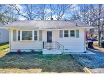 Charming single-story home with white siding, black trim, and well-maintained front yard at 210 Monk Rd, Durham, NC 27704