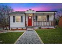 Charming single-story home featuring a welcoming porch and well-maintained front yard with a red front door at 318 Fulton St, Burlington, NC 27217