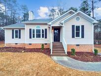 Charming single-story home with a brick foundation, manicured lawn, and inviting front entrance at 4205 Rockside Hills Dr, Raleigh, NC 27603