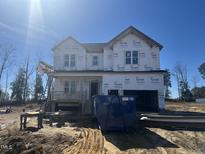 Two-story home under construction featuring a large garage and covered front porch at 49 Golden View Pl, Zebulon, NC 27597