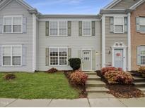 Charming townhouse with manicured lawn, colorful bushes, and inviting light green front door at 5107 Tomasita Ct, Raleigh, NC 27616