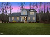 Charming two-story home with gray siding, a front porch, and a well-manicured lawn at 596 Oaks Lane Rd, Timberlake, NC 27583