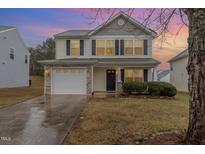Charming two-story home featuring a stone-accented garage and manicured front yard at 702 Blue Lake Dr, Mebane, NC 27302