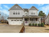 Charming two-story home featuring a covered porch, two car garage and manicured landscaping at 85 Clubhouse Dr, Youngsville, NC 27596