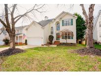Charming two-story home featuring a well-manicured lawn and attached two-car garage at 8721 Springhouse Ln, Raleigh, NC 27617