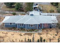 Charming single-story home featuring a gray roof, blue painted siding, and beautifully landscaped front yard at 1005 W Club Blvd, Durham, NC 27701