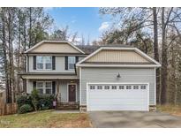 Charming two-story home featuring a two-car garage and a cozy front porch at 10504 Carsons Creek Dr, Zebulon, NC 27597