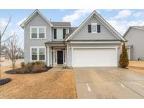 Charming two-story home featuring a two car garage, manicured lawn, and inviting front entrance at 150 Shining Amber Way, Franklinton, NC 27525