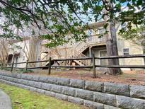 Townhome featuring wood stairs, neutral siding, and a stone retaining wall at 1513 E Franklin St # C129, Chapel Hill, NC 27514