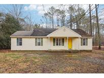 Charming single-story home with light yellow siding, green shutters, and a bright yellow front door at 195 Crooked Creek Run, Louisburg, NC 27549