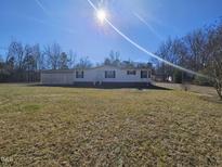 Charming single-story home featuring a well-maintained lawn on a sunny day at 2020 Sanders Rd, Stem, NC 27581