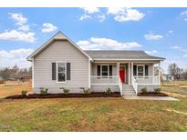Charming single-story home featuring a welcoming front porch, red front door and manicured lawn at 4610 Lemon Heights Dr, Sanford, NC 27332