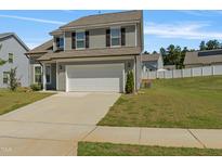 Charming two-story home with gray siding, black shutters, a two-car garage, and a well-manicured lawn at 50 Fontaine Dr, Franklinton, NC 27525
