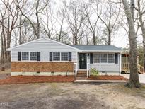 Charming single-story home featuring brick accents, neutral siding, and mature trees at 512 Trail Of Merlin, Garner, NC 27529