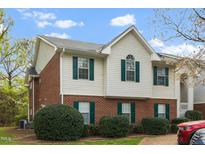 Charming townhouse with brick and siding, showcasing green shutters and manicured landscaping at 521 Renshaw Ct, Cary, NC 27518