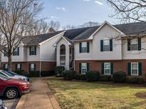 Charming condo building with traditional architecture, brick accents, and well-maintained landscaping at 521 Renshaw Ct, Cary, NC 27518
