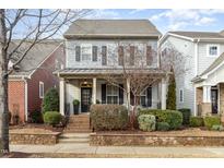 Charming two-story home with gray siding, black shutters, and a cozy front porch at 5620 Wade Park Blvd, Raleigh, NC 27607