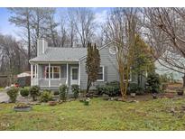 Charming cottage-style home with a cozy front porch and well-maintained landscaping at 713 Maple Shade Ln, Apex, NC 27502