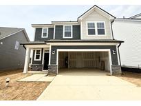 Beautiful two-story home featuring a spacious two-car garage and stone accents on the facade at 116 Willow Cameron Way, Angier, NC 27501