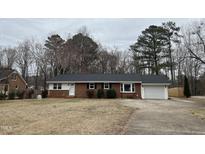 Charming one-story brick home features an attached garage and established landscaping at 1600 Buffaloe Rd, Garner, NC 27529