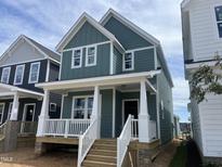 Charming two-story home featuring light green siding, white trim, a cozy front porch, and a welcoming entrance at 1905 Plott Balsam Dr, Wendell, NC 27591