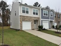 New two-story townhome featuring attached garage, neutral siding, and freshly installed lawn at 2062 Glen Crossing Rd Dr, Durham, NC 27704