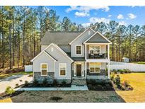 Beautiful two-story home featuring stone accents, covered porch, and well-maintained landscaping at 220 Green Haven Blvd, Youngsville, NC 27596