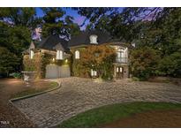 Stunning stone home featuring a circular driveway, ivy covered walls, and a beautiful balcony at 2658 Davis St, Raleigh, NC 27608