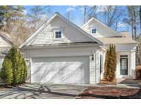 Inviting exterior showcasing a white home with a large two-car garage and well-manicured landscaping at 314 Fenmore Pl, Cary, NC 27519