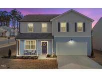 Charming two-story home with a well-maintained lawn, a welcoming front porch, and an attached two-car garage at 3512 Dragonfly River Ct, Raleigh, NC 27604