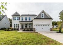Inviting two-story home with a manicured lawn, attached two car garage, and classic architectural details at 3529 Bailey Lk Dr, Fuquay Varina, NC 27526