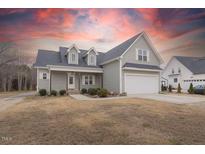 Charming two-story home with gray siding and an attached two-car garage at sunset at 375 Thomas Arnold Rd, Zebulon, NC 27597