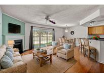 Bright living room featuring hardwood floors, a fireplace, and sliding glass doors to outdoor space at 7712 Falcon Rest Cir, Raleigh, NC 27615