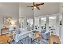 Bright living room boasts a ceiling fan, hardwood floors, and a view into other rooms with white trim and shelving at 8116 Hartwood Glen Cir, Willow Springs, NC 27592
