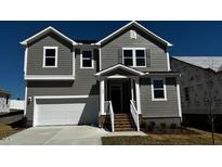 Charming two-story home with gray siding, white trim, a two-car garage, and a cozy front porch at 937 Emmer St, Rolesville, NC 27571